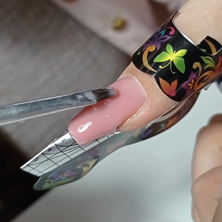 Alumna construyendo uñas artificiales con gel y moldes esculturales