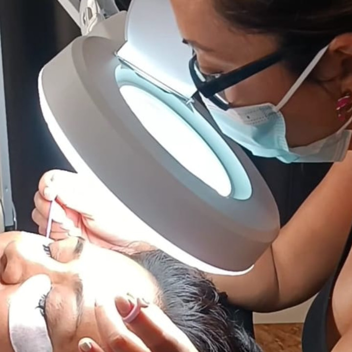 alumna aplicando extensiones de pestañas en el curso presencial